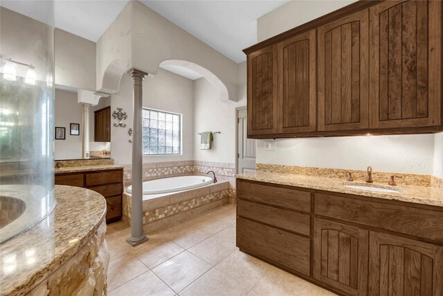 202 Bridgepoint Dr, Kingsland, TX 78639 - bathroom with ornate columns, a garden tub, two vanities, and tile patterned floors