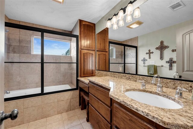 202 Bridgepoint Dr, Kingsland, TX 78639 - bathroom featuring tiled shower / bath, vanity, and tile patterned floors