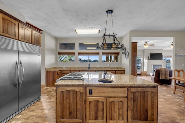 202 Bridgepoint Dr, Kingsland, TX 78639 - kitchen featuring stainless steel appliances, ceiling fan, light stone countertops, a sink, and healthy amount of natural light