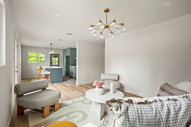 7614 Watson St, Austin, TX 78757 - living room featuring light wood finished floors, a chandelier, and baseboards