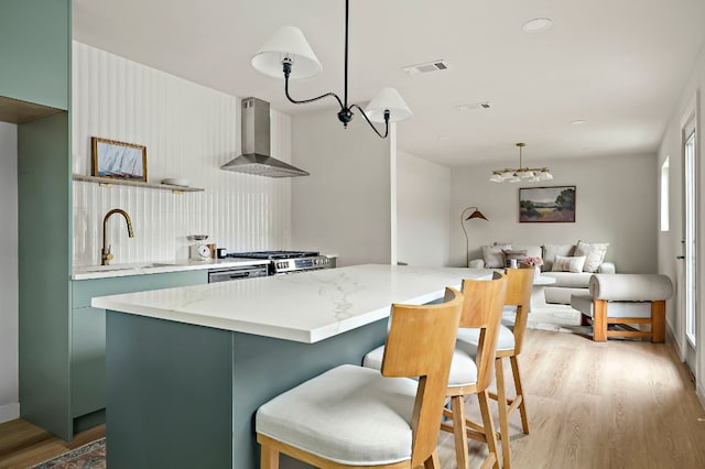 7614 Watson St, Austin, TX 78757 - kitchen featuring wall chimney exhaust hood, a sink, light wood-style floors, and range