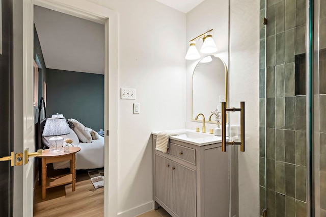 7614 Watson St, Austin, TX 78757 - full bathroom with vanity, wood finished floors, a shower stall, and baseboards