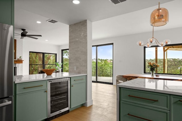 4328 Far W Blvd, Austin, TX 78731 - kitchen featuring green cabinets, wine cooler, freestanding refrigerator, light wood-type flooring, and hanging light fixtures