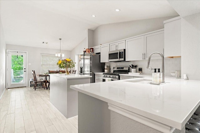 4456 Mather, Kyle, TX 78640 - kitchen with stainless steel appliances, a kitchen island, lofted ceiling, backsplash, and a sink