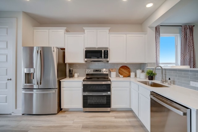 2031 Cora Ivy Ln, Round Rock, TX 78665 - kitchen with stainless steel appliances, a sink, white cabinets, light countertops, and recessed lighting