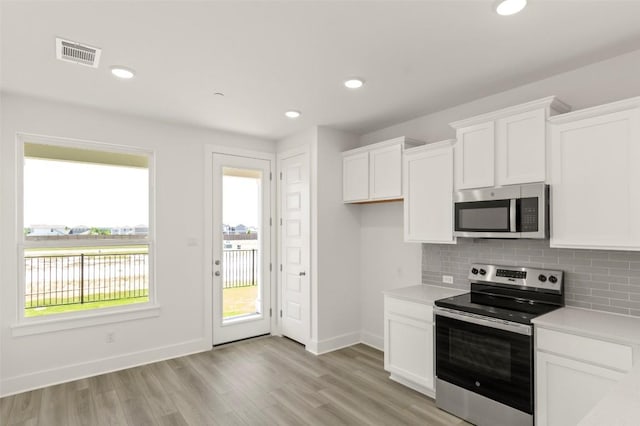 2031 Cora Ivy Ln, Round Rock, TX 78665 - kitchen featuring appliances with stainless steel finishes, white cabinetry, baseboards, light countertops, and tasteful backsplash