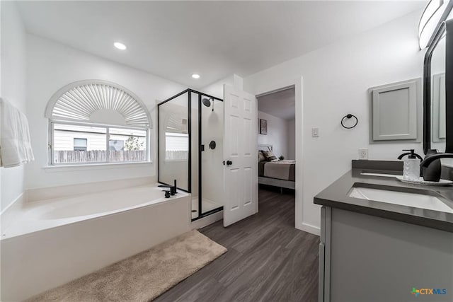 full bathroom featuring ensuite bathroom, a bath, a sink, wood finished floors, and a stall shower