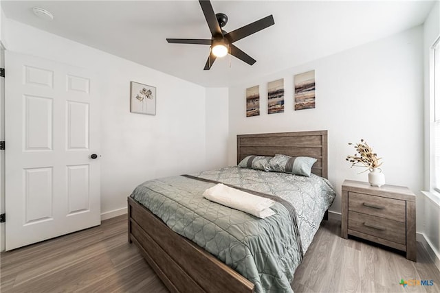 bedroom featuring baseboards, ceiling fan, and wood finished floors