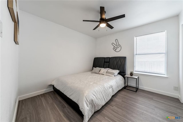 bedroom with ceiling fan, baseboards, and wood finished floors