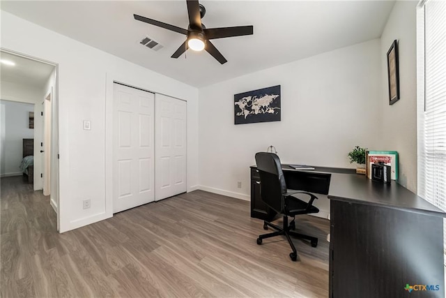 office area with visible vents, baseboards, a ceiling fan, and light wood-style floors