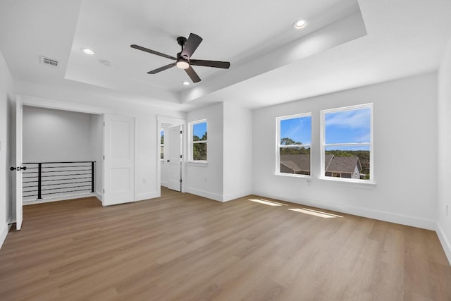 240 Hanauma Dr, Bastrop, TX 78602 - unfurnished bedroom featuring a raised ceiling, light wood finished floors, baseboards, recessed lighting, and ceiling fan