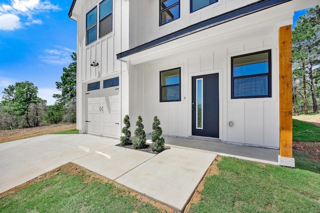 240 Hanauma Dr, Bastrop, TX 78602 - doorway to property featuring board and batten siding, an attached garage, and concrete driveway
