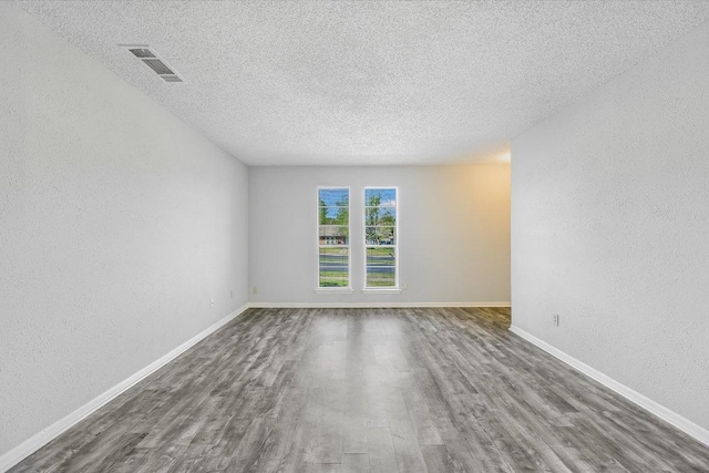317 W William Cannon Dr B, Unit A, Austin, TX 78745 - empty room with wood finished floors, a textured ceiling, a textured wall, and baseboards