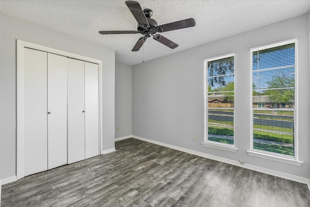 317 W William Cannon Dr B, Unit A, Austin, TX 78745 - unfurnished bedroom featuring wood finished floors, a closet, a textured ceiling, baseboards, and a ceiling fan