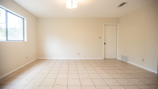 unfurnished room featuring baseboards, light tile patterned flooring, and visible vents
