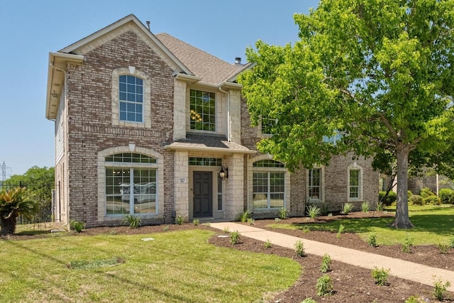 6611 Yaupon Dr, Austin, TX 78759 - traditional-style house with a front yard, brick siding, and roof with shingles