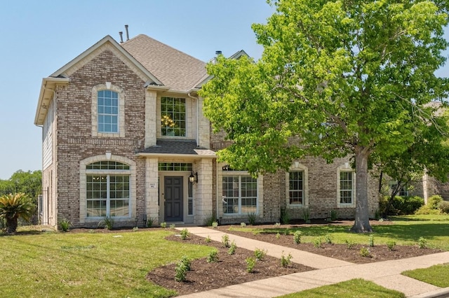6611 Yaupon Dr, Austin, TX 78759 - traditional home featuring a front lawn, brick siding, and roof with shingles