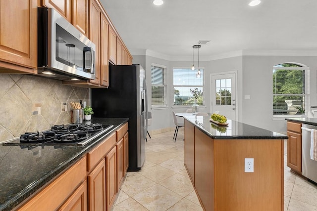 6611 Yaupon Dr, Austin, TX 78759 - kitchen featuring stainless steel appliances, a kitchen island, ornamental molding, plenty of natural light, and backsplash