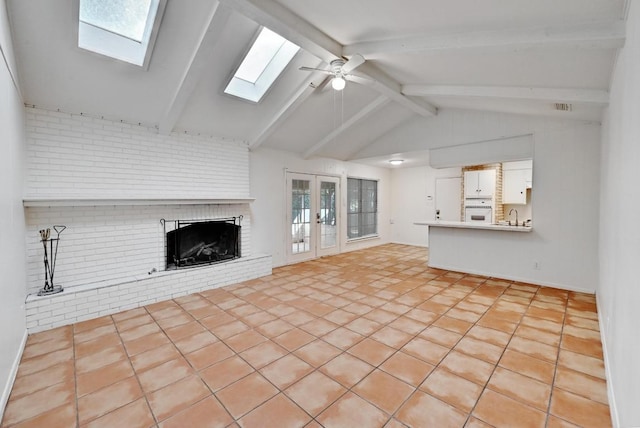 1700 Barton Hills Dr, Austin, TX 78704 - unfurnished living room with a fireplace, a skylight, a ceiling fan, and healthy amount of natural light