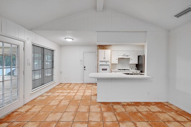 1700 Barton Hills Dr, Austin, TX 78704 - kitchen with white appliances, light tile patterned floors, light countertops, white cabinetry, and under cabinet range hood