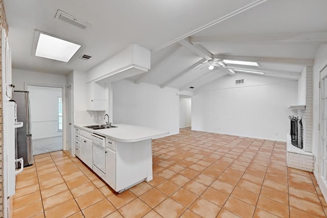 1700 Barton Hills Dr, Austin, TX 78704 - kitchen featuring dishwasher, a peninsula, open floor plan, a skylight, and white cabinets