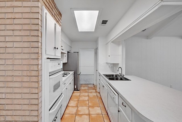 1700 Barton Hills Dr, Austin, TX 78704 - kitchen featuring white appliances, a warming drawer, white cabinetry, light countertops, and brick wall