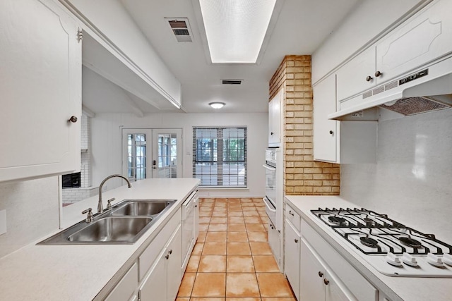 1700 Barton Hills Dr, Austin, TX 78704 - kitchen with under cabinet range hood, white appliances, backsplash, and white cabinets