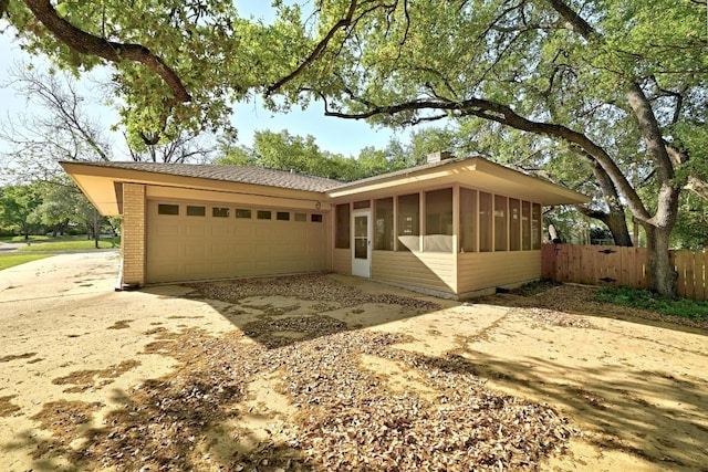 1700 Barton Hills Dr, Austin, TX 78704 - view of front facade with a sunroom, driveway, a garage, and brick siding
