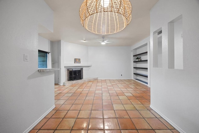 8200 Neely Dr Unit 103, Austin, TX 78759 - unfurnished living room with built in features, baseboards, a fireplace with raised hearth, and light tile patterned floors