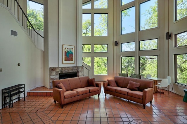 8200 Neely Dr Unit 103, Austin, TX 78759 - living area with a high ceiling, a tiled fireplace, baseboards, light tile patterned floors, and stairway