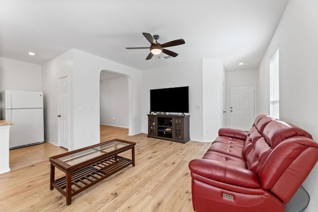 living room with recessed lighting, a ceiling fan, light wood-style floors, visible vents, and arched walkways