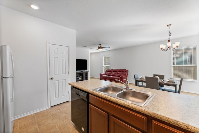 kitchen with a sink, light countertops, freestanding refrigerator, and dishwasher