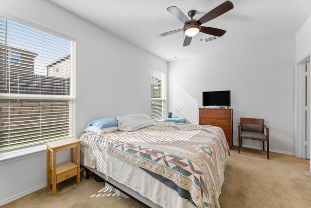 carpeted bedroom with ceiling fan, baseboards, and visible vents