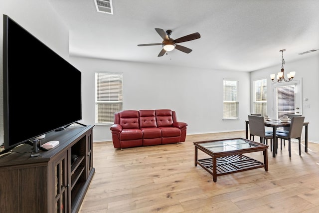 living area with light wood finished floors, visible vents, and a wealth of natural light