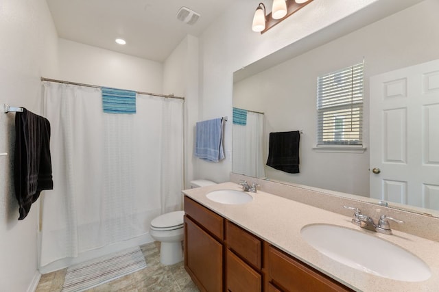 full bath featuring a sink, visible vents, toilet, and double vanity