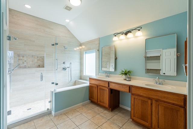 3610 Turkey Path Bnd, Cedar Park, TX 78613 - full bathroom with lofted ceiling, tile patterned flooring, double vanity, a shower stall, and a bathtub