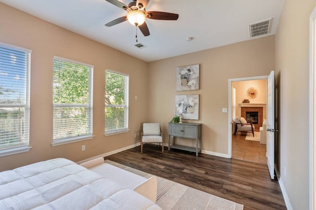 3610 Turkey Path Bnd, Cedar Park, TX 78613 - bedroom featuring dark wood-type flooring, a tiled fireplace, and ceiling fan