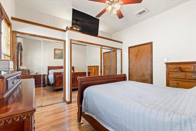 406 Garwood St, Smithville, TX 78957 - bedroom with light wood-style flooring, two closets, and a ceiling fan