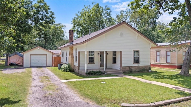 406 Garwood St, Smithville, TX 78957 - view of front of property featuring covered porch, driveway, an outbuilding, a garage, and a front yard