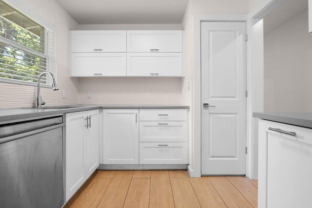 11907 Pollyanna Ave, Austin, TX 78753 - kitchen featuring stainless steel dishwasher, light wood finished floors, white cabinetry, and a sink