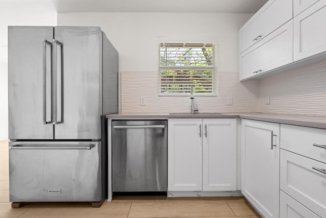 11907 Pollyanna Ave, Austin, TX 78753 - kitchen with white cabinetry, appliances with stainless steel finishes, light countertops, a sink, and backsplash
