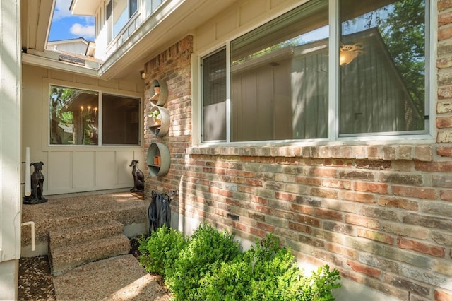 view of property exterior featuring brick siding and board and batten siding