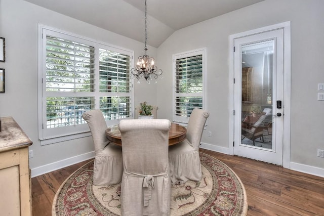 dining space featuring baseboards, wood finished floors, a chandelier, and vaulted ceiling