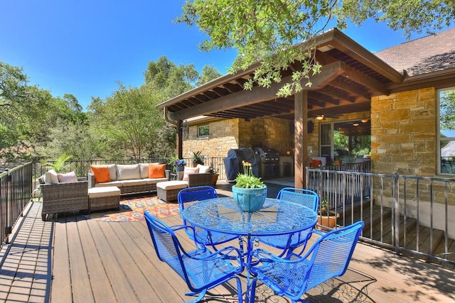 wooden terrace featuring area for grilling, outdoor dining space, and an outdoor hangout area
