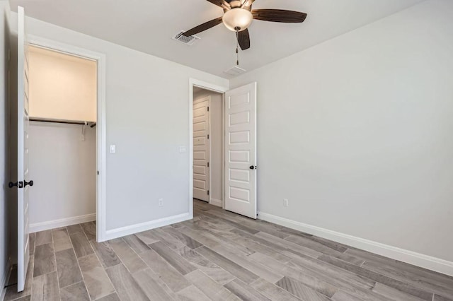 unfurnished bedroom with light wood-style flooring, a closet, baseboards, and visible vents