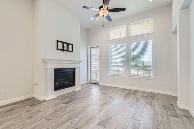 unfurnished living room with light wood-style flooring, ceiling fan, and a healthy amount of sunlight