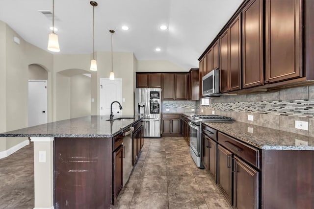 3613 Esperanza Dr, Round Rock, TX 78665 - kitchen featuring stainless steel appliances, a sink, backsplash, arched walkways, and dark stone counters