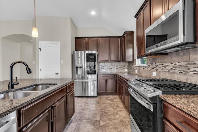 3613 Esperanza Dr, Round Rock, TX 78665 - kitchen featuring appliances with stainless steel finishes, a sink, tasteful backsplash, lofted ceiling, and dark stone countertops