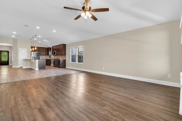 3613 Esperanza Dr, Round Rock, TX 78665 - unfurnished living room featuring arched walkways, ceiling fan, baseboards, vaulted ceiling, and recessed lighting