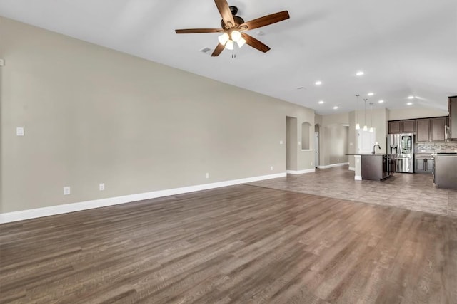 3613 Esperanza Dr, Round Rock, TX 78665 - unfurnished living room featuring ceiling fan, baseboards, recessed lighting, dark wood-style flooring, and lofted ceiling